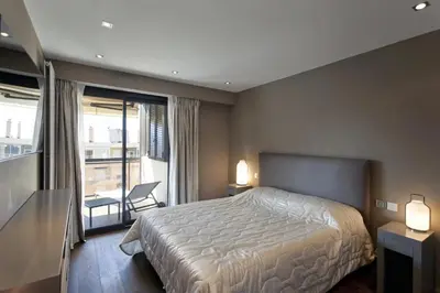 a bedroom with a large bed and a balcony at 2 chambres au cœur de Cannes - Croisette et plages à 1 min in Cannes