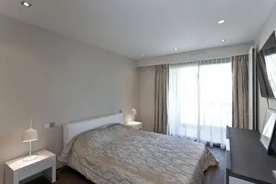 a bedroom with a bed and a large window at 2 chambres au cœur de Cannes - Croisette et plages à 1 min in Cannes
