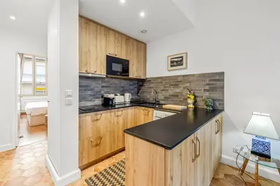 a kitchen with wooden cabinets and a black counter top at REF 2038 - Cannes - Superb fully renovated one-bedroom apartment in Cannes