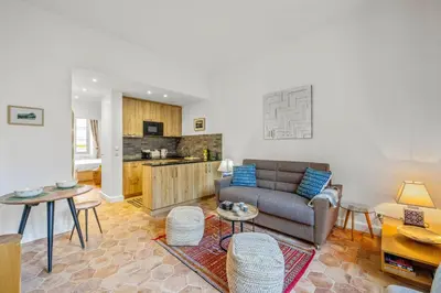 a living room with a couch and a kitchen at REF 2038 - Cannes - Superb fully renovated one-bedroom apartment in Cannes