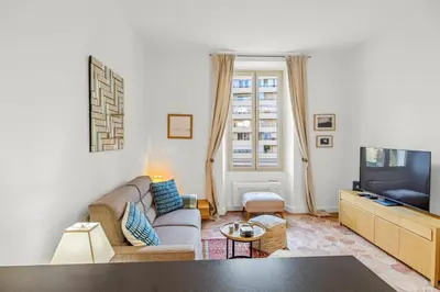 a living room with a couch and a tv at REF 2038 - Cannes - Superb fully renovated one-bedroom apartment in Cannes