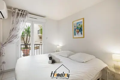 a bedroom with a white bed with a clock on it at Le Palazzio in Cannes