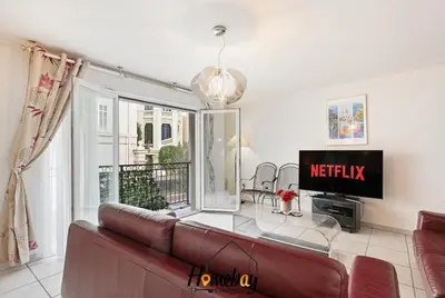 a living room with a couch and a tv at Le Palazzio in Cannes