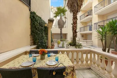 a table with plates and glasses on a balcony at Le Palazzio in Cannes