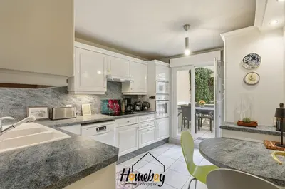 a kitchen with white cabinets and a dining room at Le Palazzio in Cannes
