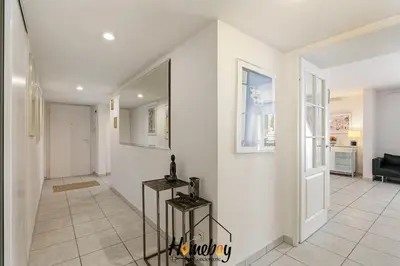 a hallway with white walls and a white tile floor at Le Palazzio in Cannes
