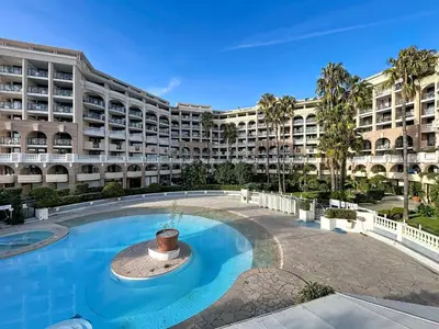 a large apartment building with a large swimming pool at Bleu Azur - 2 piscines & plage à 200m in Cannes