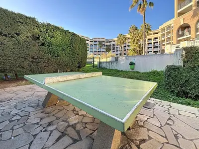 a green ping pong table sitting on a stone patio at Bleu Azur - 2 piscines & plage à 200m in Cannes