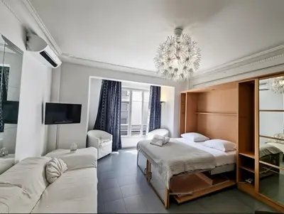 a bedroom with a bed and a couch and a tv at Charming Studio near Croisette in Cannes