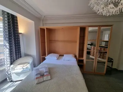 a small bedroom with two beds and a chandelier at Charming Studio near Croisette in Cannes
