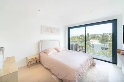 a white bedroom with a bed and a large window at COZYSTAY 1700 -Luxury 3-Bedroom Apartment with Terrace & Sea View in Cannes in Cannes