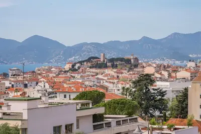 a view of a city with mountains in the background at COZYSTAY 1700 -Luxury 3-Bedroom Apartment with Terrace & Sea View in Cannes in Cannes