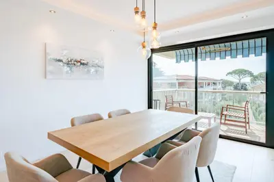 a dining room with a wooden table and chairs at COZYSTAY 1700 -Luxury 3-Bedroom Apartment with Terrace & Sea View in Cannes in Cannes