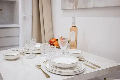 a table with plates and glasses and a bottle of wine at Studio Méro by Halldis in Cannes