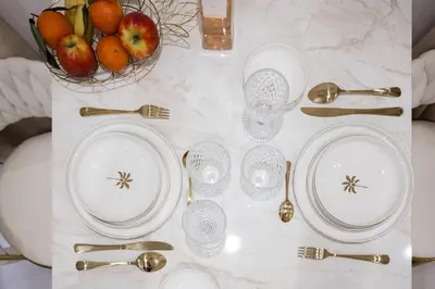 a table with plates and spoons and a bowl of fruit at Studio Méro by Halldis in Cannes