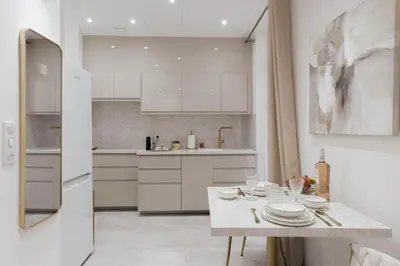 a white kitchen with a table with plates on it at Studio Méro by Halldis in Cannes