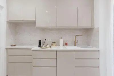 a white kitchen with white cabinets and a sink at Studio Méro by Halldis in Cannes