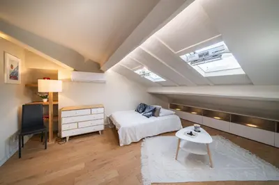 a attic bedroom with a bed and a table at Elegant renovated studio on the top floor Cannes city center in Cannes