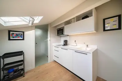 a kitchen with white cabinets and a sink at Elegant renovated studio on the top floor Cannes city center in Cannes