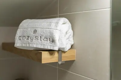 a towel on a wooden shelf in a bathroom at Elegant renovated studio on the top floor Cannes city center in Cannes