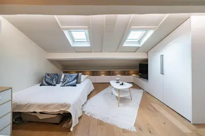 a attic bedroom with a bed and a table at Elegant renovated studio on the top floor Cannes city center in Cannes
