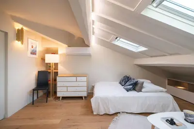 a attic bedroom with two beds and a desk at Elegant renovated studio on the top floor Cannes city center in Cannes