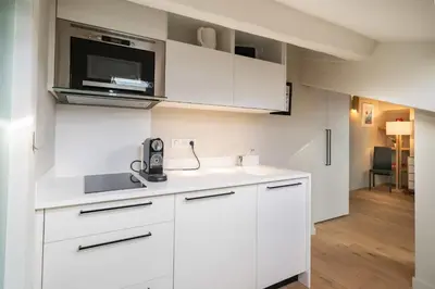 a kitchen with white cabinets and a microwave at Elegant renovated studio on the top floor Cannes city center in Cannes