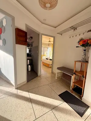 a living room with a vase of flowers on the floor at Le Marvel By ApiRent #Climatisation #Central #Balcon in Cannes
