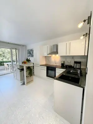 a kitchen with white cabinets and a counter top at Long Beach Apartment Cannes in Cannes