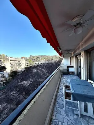 a balcony with a table and a ceiling fan at T2 derrière le Martinez - Croisette in Cannes