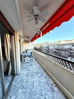 a balcony with a table and a ceiling fan at T2 derrière le Martinez - Croisette in Cannes