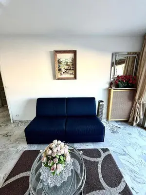 a living room with a blue couch and a glass table at T2 derrière le Martinez - Croisette in Cannes