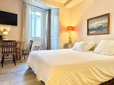 a bedroom with a large white bed and a table at Elegant studio in Cannes - Le Suquet - 2 people in Cannes