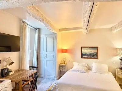 a bedroom with a bed and a wooden table at Elegant studio in Cannes - Le Suquet - 2 people in Cannes