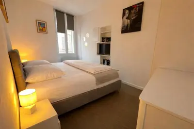 a white bedroom with a bed and a window at Cannes one bedroom apartment - 12RP2 in Cannes