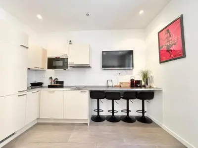 a kitchen with white cabinets and a black counter top at Cannes one bedroom apartment - 12RP2 in Cannes