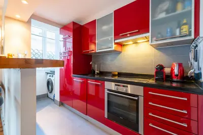 a kitchen with red cabinets and a stove at 1-Br Apartment in Cannes Peaceful Seaside Atmosphere in Cannes