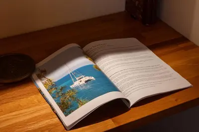 an open book on a table with a boat on it at 1-Br Apartment in Cannes Peaceful Seaside Atmosphere in Cannes