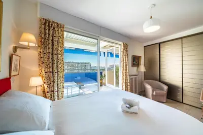 a bedroom with a large white bed and a large window at Top floor 3 Bedroom near the Croisette in Cannes