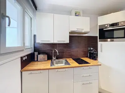 a kitchen with white cabinets and a sink at Superbe appartement meublé Cannes centre in Cannes