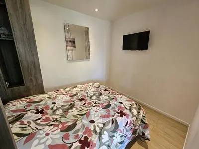 a bedroom with a bed with a floral bedspread at Superbe appartement meublé Cannes centre in Cannes