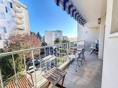a balcony with a table and chairs on a building at Superbe appartement meublé Cannes centre in Cannes