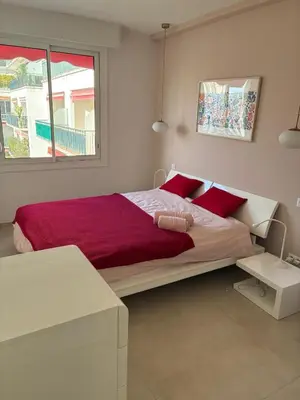 a bedroom with a large bed with red pillows at Armenonvillecannes in Cannes