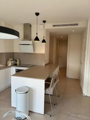 a kitchen with a counter and some chairs in it at Armenonvillecannes in Cannes