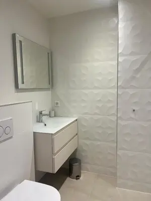 a white bathroom with a sink and a shower at Armenonvillecannes in Cannes