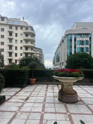a stone fountain in a courtyard with buildings at Armenonvillecannes in Cannes