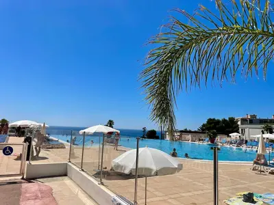 a swimming pool with umbrellas and the ocean at Splendid view Apartment in Cannes in Cannes