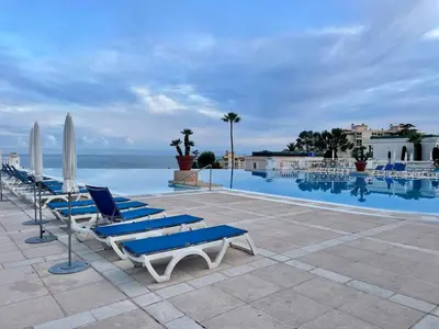 a row of lounge chairs and umbrellas next to a swimming pool at Splendid view Apartment in Cannes in Cannes