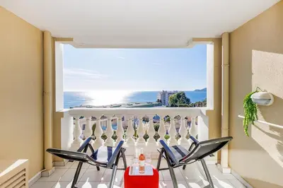 a room with chairs and a large window with the ocean at Vue mer piscine parking tennis 4 personnes in Cannes