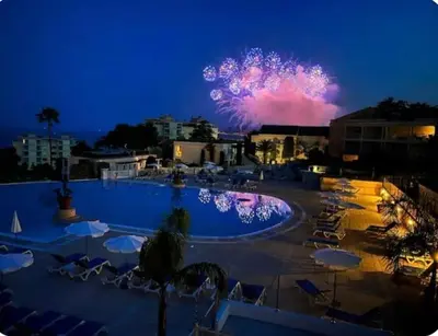 a pool with a fire show in the sky at night at Vue mer piscine parking tennis 4 personnes in Cannes